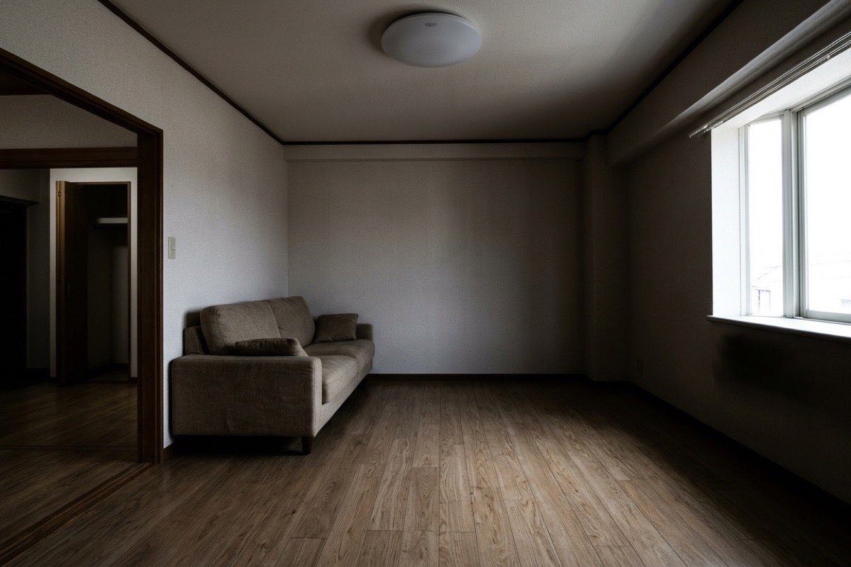 補正前：窓に露出を合わせたため室内が暗く沈んだリビング